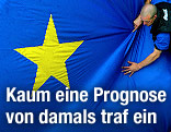 Ein Mann zieht an einer gro&szlig;en EU-Fahne