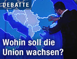 Ein Mann ber&uuml;hrt eine beleuchtete Europakarte