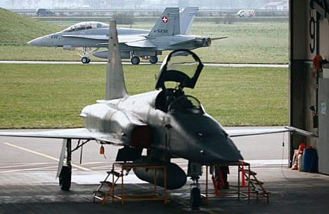 © Reuters/Ruben Sprich Schweizer Northrop F-5 Tiger parkt vor einem voerbeifahrenden F/A 18-Kampfflugzeug