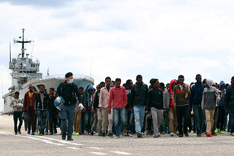 © Reuters/Antonio Parrinello Flüchtlinge werden von der Polizei von einem Boot eskortiert