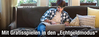 Junger Mann hinter Laptop