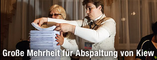 Wahlhelferinnen stapeln die ausgewerteten Stimmzettel übereinander