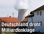 Kühlturm des AKWs Isar 1 und 2 hinter Häusern eines bayrischen Dorfes