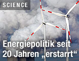 Windräder vor dem Rauch eines Kraftwerkkühlturms