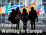 Umrisse von Personen vor den Flaggen verschiedener EU-Staaten