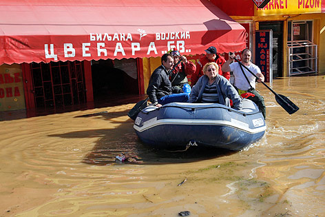 © AP/Darko Vojinovic Personen fahren in einem Schlauchboot durch die überflutete serbische Ortschaft Obrenovac