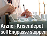 Apothekerin &ouml;ffnet eine Lade mit Medikamenten