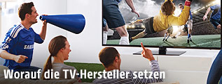 Fans vor einem UHD-Fernseher mit einer Fußballszene