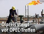 Ein Arbeiter auf einer irakischen Raffinerie dreht an einem Hahn