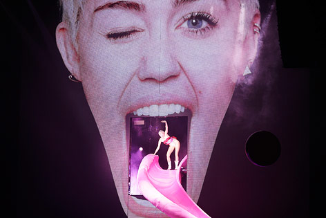 © APA/EPA/Georg Hochmuth Miley Cyrus auf einer pinken Rutsche
