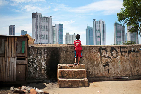 © AP/Dita Alangkara Kleiner Junge blickt auf die Skyline von Jakarta