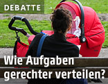 Frau sitzt auf Parkbank, vor ihr ein Kinderwagen