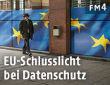 Mann vor Geb&auml;ude mit EU-Fahne