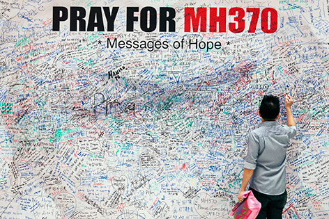 © APA/EPA/Azhar Rahim Mann unterschreibt auf Gedenkwand für Flug MH370