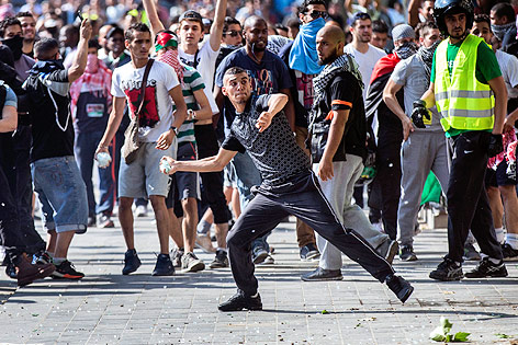 © APA/EPA/Etienne Laurent Ein Demonstrant wirft einen Stein