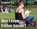 Eine Frau liest in der Wiese ein Buch