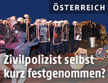 Polizisten stehen stehen bei randelierenden Demonstranten