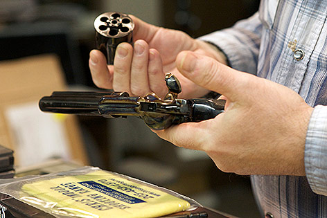 © Reuters/Michelle McLoughlin Mann hält einen Colt Single Action Army-Revolver