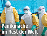 Mediziner in Schutzanzügen