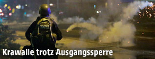 Polizist vor einer Tränengasgranate