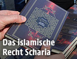 Eine Person hält eine Ausgabe des Koran in den Händen