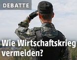 Ein ukrainischer Soldat blickt von einem Dach in die Ferne