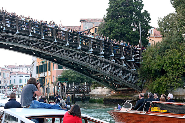 © APA/EPA/Alessandro di Meo Schaulustige stehen auf einer Brücke während George Clooney auf Boot vorbeifährt