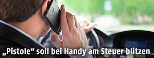 Geschäftsmann fährt mit dem Auto und telefoniert währenddessen mit seinem Mobiltelefon