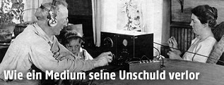 Mann sitzt mit einem Buben vor dem Radioger&auml;t