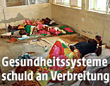 Patienten liegen in einem afrikanischen Krankenhaus am Boden auf einer Matratze