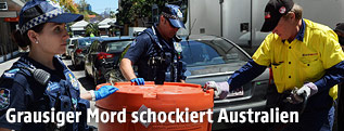 Polizisten mit einer Plastiktonne