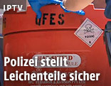 Polizisten mit einer Plastiktonne