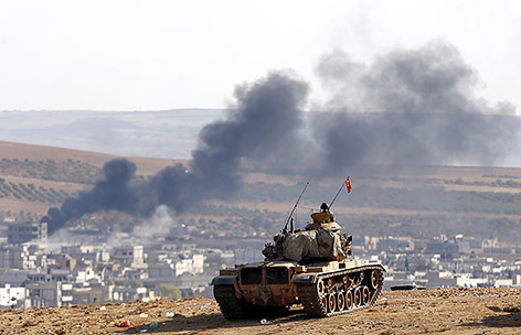 © APA/EPA/Sedat Suna Türkischer Panzer steht auf einem Hügel mit Blick auf eine Rauchsäule in der syrischen Stadt Kobane