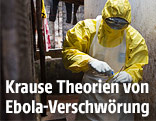 Medizinischer Mitarbeiter in Schutzkleidung entnimmt eine Probe