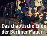 Menschen klettern auf die Berliner Mauer