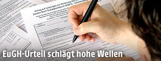 Person f&uuml;llt einen deutschen Arbeitslosengeld-Antrag aus