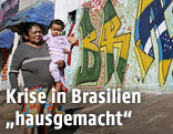 Frau mit Kind auf einer Straße mit Graffiti im Hintergrund