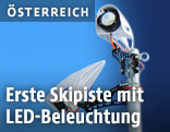 Arbeiter installieren LED-Beleuchtung auf einer Skipiste