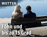 Zwei Menschen auf einer Bank bei einem See