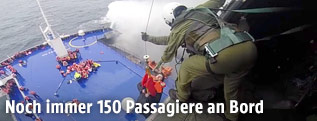 Bergung von Passagieren durch ein Rettungsteam in einem Hubschrauber &uuml;ber der F&auml;hre