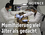 Wissenschafter mit einer Mumie