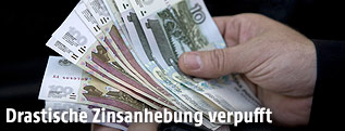 Mann hält Rubel in der Hand