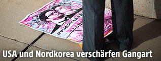 Plakat des Films "The Interview" auf dem Boden neben den Beinen eines Mannes