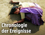 Weinende Frau liegt im Sand