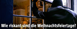 Mann bricht durch ein Fenster ein