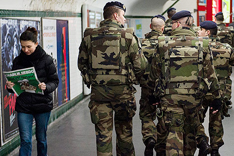 © APA/EPA/Yoan Valat Person liest "Charlie Hebdo"