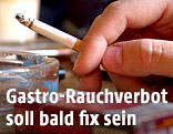 Hand hält brennende Zigarette