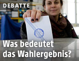 Stimmzettel wird in Urne geworfen