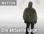 Mann steht in Schneesturm