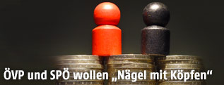 Schwarze und rote Spielfigur auf Münzenstapel